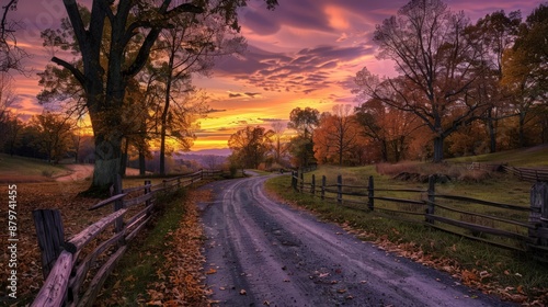 A country road lined with split-rail fences and trees shedding their leaves in shades