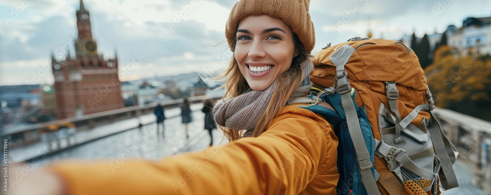 Cheerful female traveler taking a selfie in a scenic cityscape backdrop with a historic building. Autumn travel adventure. Cheerful female traveler taking a selfie in a scenic cityscape backdrop with a historic building. Autumn travel adventure.