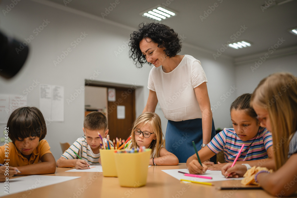Young students paint and draw on class in the classroom with teacher Young students paint and draw on class in the classroom with teacher