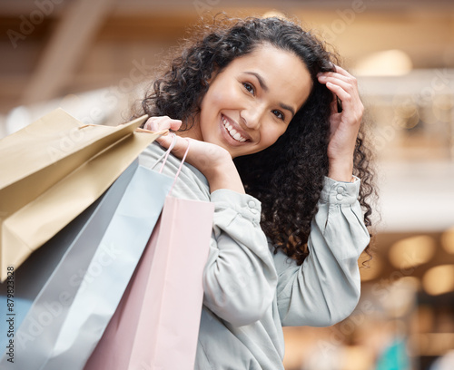 Happy woman, portrait and fashion with shopping bags at mall for purchase, deal or buying spree. Young female person, customer or shopper with smile for gift, present or discount sale at retail store