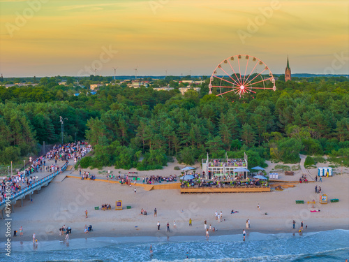 Ferris wheel in the city next to the beach among the trees in the evening. Aerial drone sunset photo, Palanga, Lithuania photo