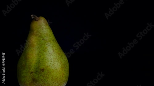a green pear on a dark background