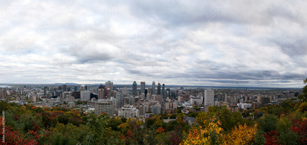 An expansive panorama of Montreal as seen from Mount Royal, featuring the city skyline under a dramatic sky, bordered by the fiery hues of autumn foliage. An expansive panorama of Montreal as seen from Mount Royal, featuring the city skyline under a dramatic sky, bordered by the fiery hues of autumn foliage.