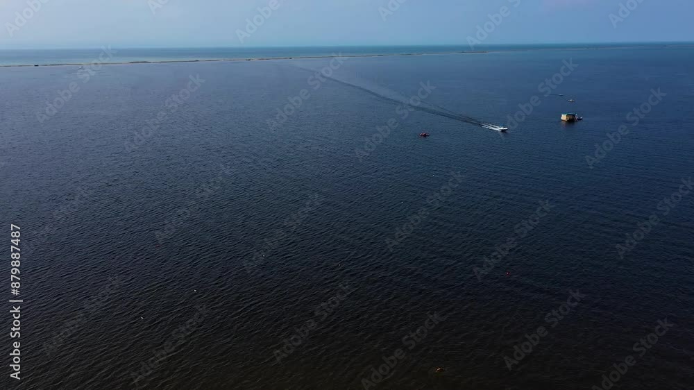 Taking in a serene aerial perspective of a tranquil sea with boats and a dock in the distance Taking in a serene aerial perspective of a tranquil sea with boats and a dock in the distance