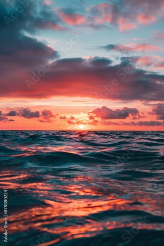 Vibrant sunset over calm ocean, sky painted in brilliant shades of orange, pink