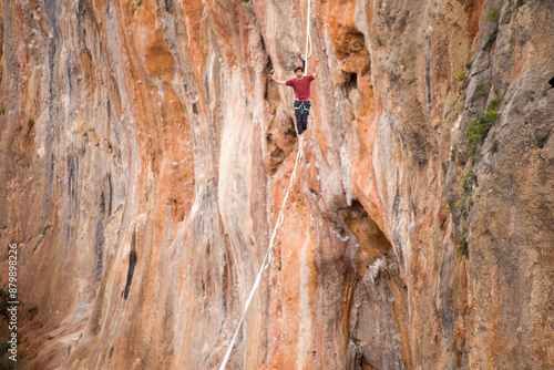 A man walks on a tightrope over an abyss.