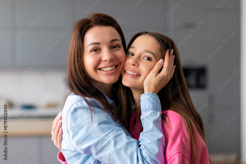 Happy young mother embracing with her teen daughter kid touching faces, enjoying warm family moment, expressing love, affection Happy young mother embracing with her teen daughter kid touching faces, enjoying warm family moment, expressing love, affection