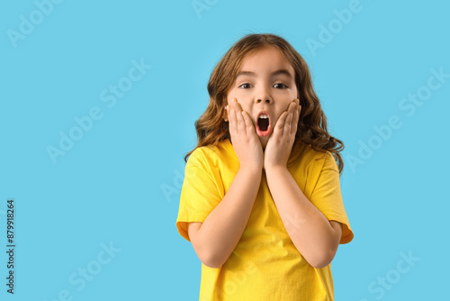 Shocked little girl on blue...