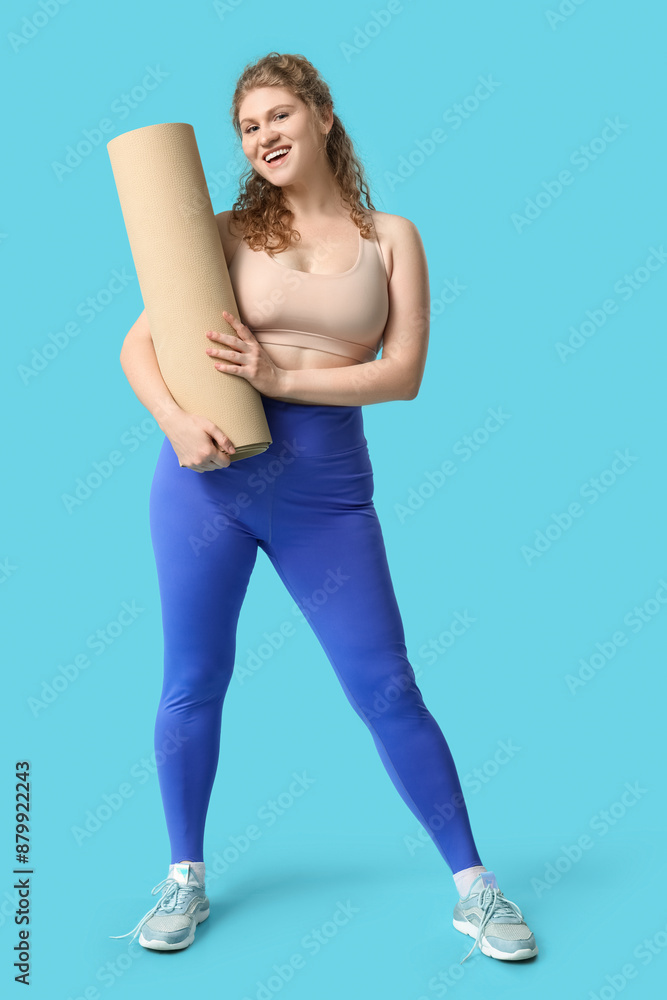 Sporty young woman with yoga mat on blue background Sporty young woman with yoga mat on blue background