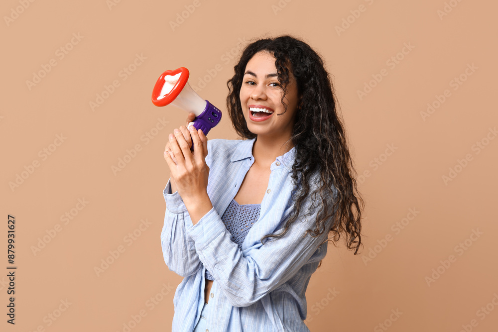 Young African-American woman with funny megaphone on beige background Young African-American woman with funny megaphone on beige background