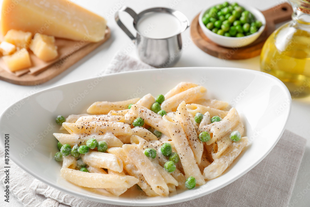 Delicious pasta with green peas and other ingredients on white table Delicious pasta with green peas and other ingredients on white table