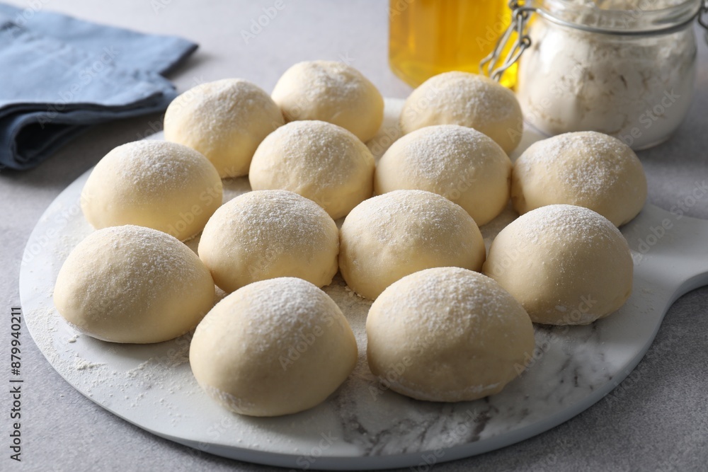 Raw dough balls and flour on light grey table Raw dough balls and flour on light grey table
