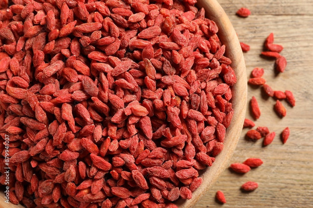 Dried goji berries in bowl on wooden table, top view Dried goji berries in bowl on wooden table, top view