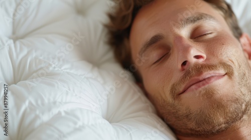 This image shows a close-up of a man resting on a comfortable, soft white bed, exemplifying restful sleep and calm, with smooth, plush bedding contributing to tranquility.