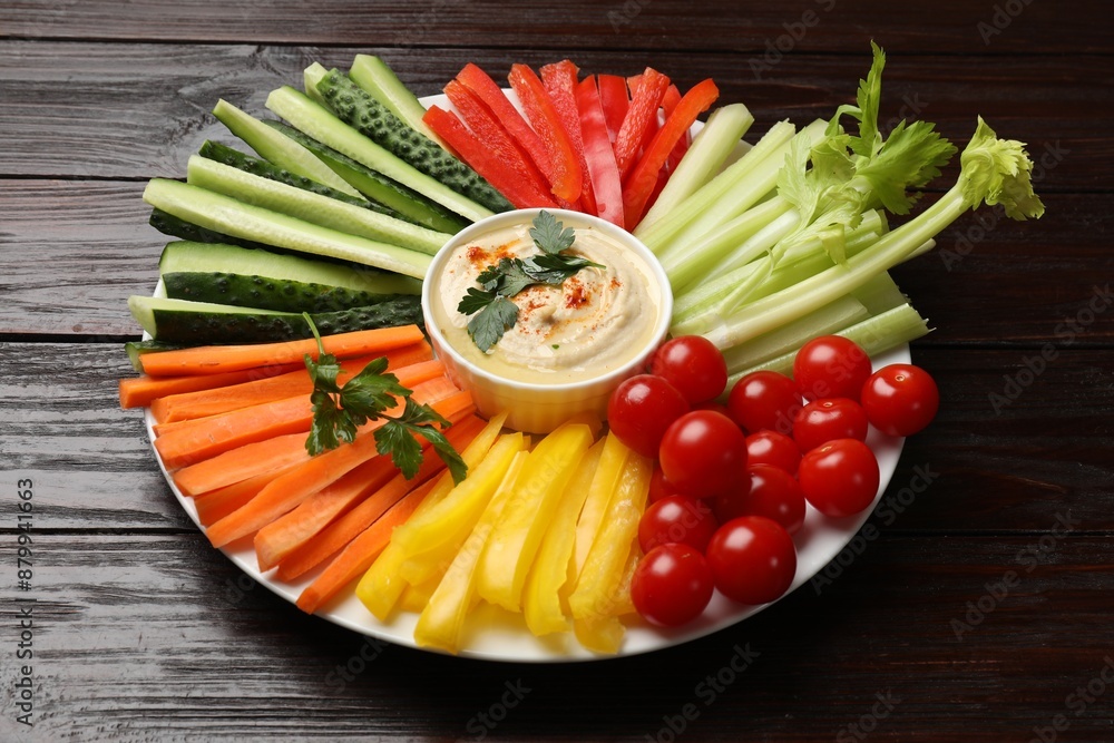 Tasty homemade hummus and different vegetables on dark wooden table Tasty homemade hummus and different vegetables on dark wooden table