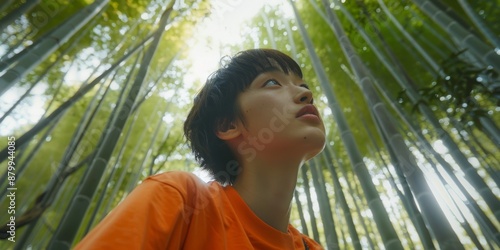 Japanese man, bamboo trees, and nature on walk, adventure, and hike with thoughts and travel. Kyoto vacationer walking Fushimi Inari for peace, awareness, or woods. photo