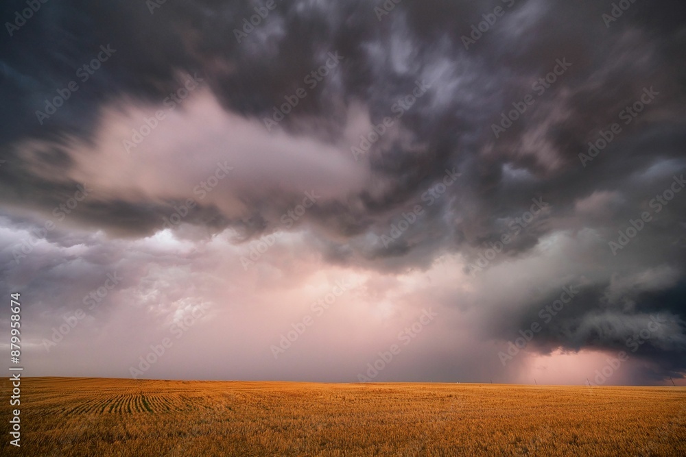 Dramatic view of a stormy sky with lightning striking over a green field in Nebraska Plains, USA
