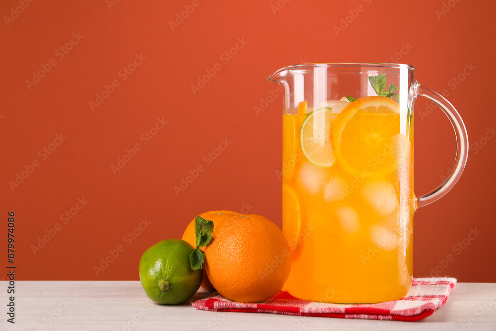 Freshly made lemonade in jug and citrus fruits on light wooden table, space for text Freshly made lemonade in jug and citrus fruits on light wooden table, space for text