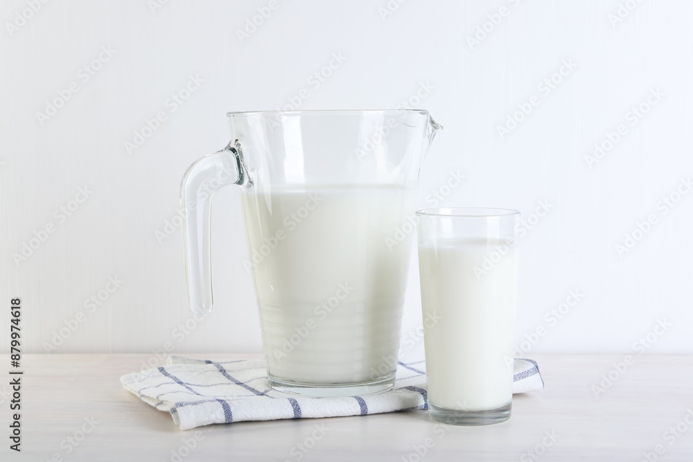 Jug and glass of fresh milk on wooden table Jug and glass of fresh milk on wooden table