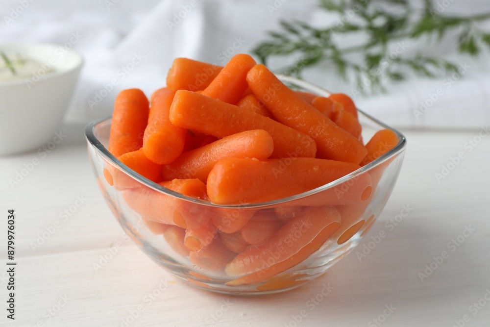 Baby carrots in glass bowl on white wooden table Baby carrots in glass bowl on white wooden table