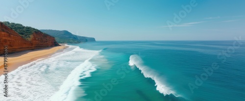 Drone capture of a coastal cliffside with waves crashing against the rocks and a clear horizon