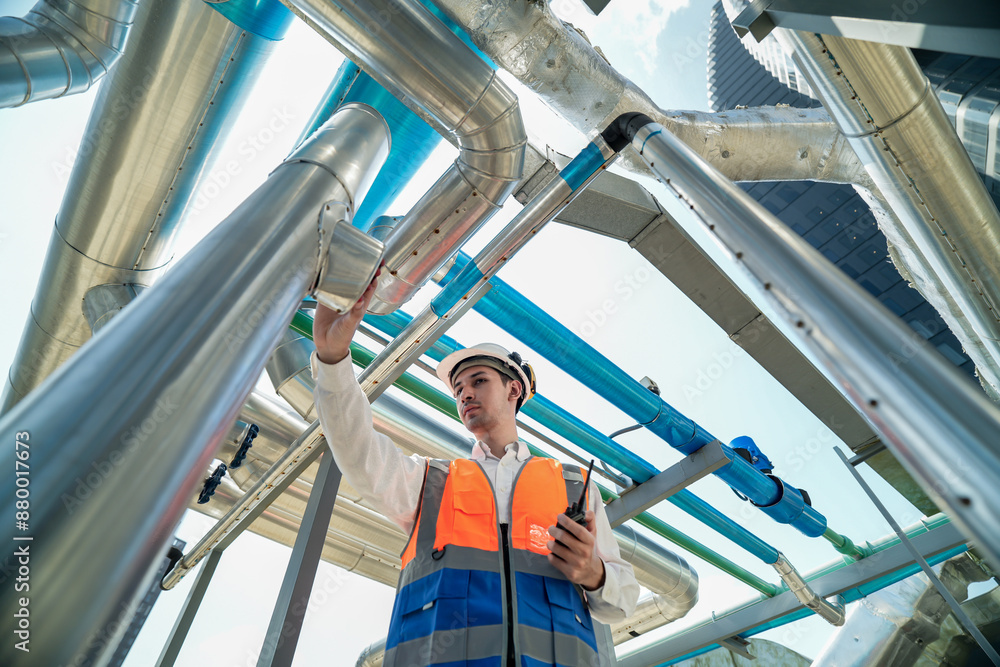 Male engineer inspects air and water pipelines in the engineering system area of the factory outside where various pipelines are designed modernly. Technicians work in the petrochemical industry. Male engineer inspects air and water pipelines in the engineering system area of the factory outside where various pipelines are designed modernly. Technicians work in the petrochemical industry.