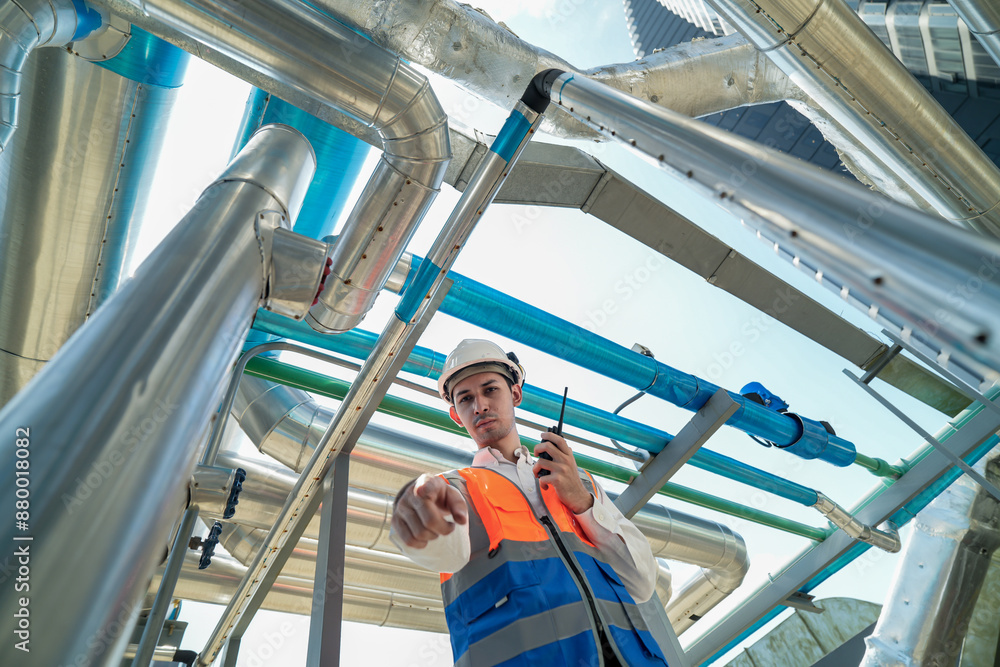 Male engineer inspects air and water pipelines in the engineering system area of the factory outside where various pipelines are designed modernly. Technicians work in the petrochemical industry. Male engineer inspects air and water pipelines in the engineering system area of the factory outside where various pipelines are designed modernly. Technicians work in the petrochemical industry.