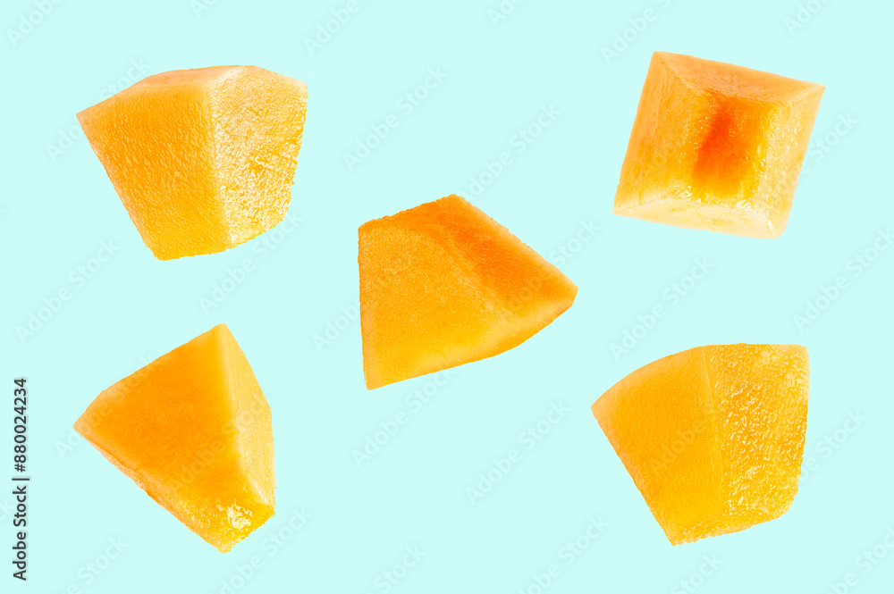 Falling slices of cantaloupe melon on light green background. Falling slices of cantaloupe melon on light green background.