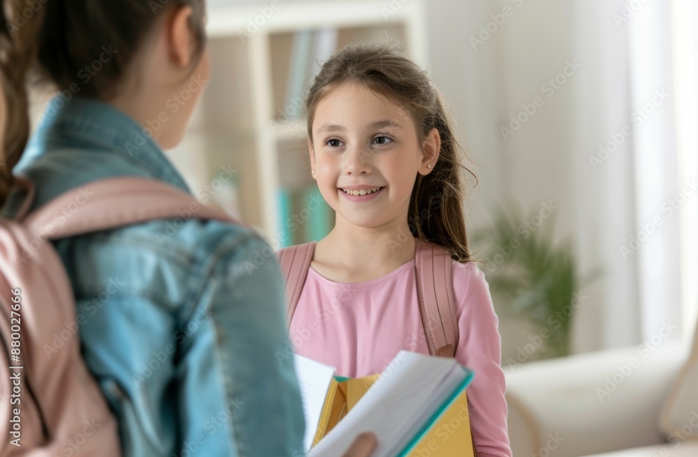 A girl is smiling at another girl while holding a book A girl is smiling at another girl while holding a book
