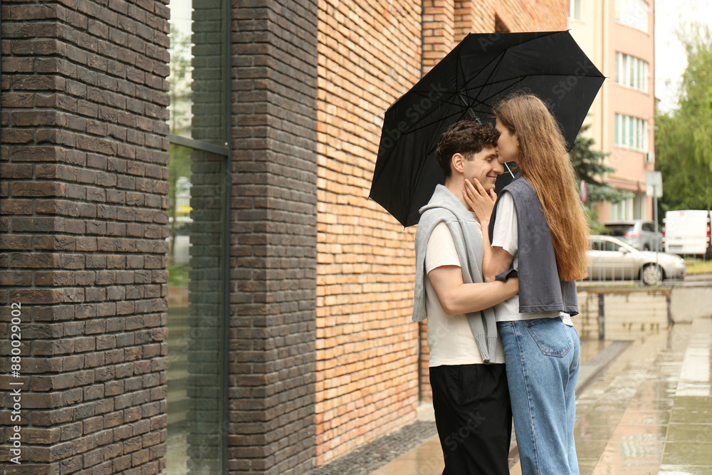 Fototapeta premium International dating. Lovely young couple with umbrella spending time together outdoors, space for text