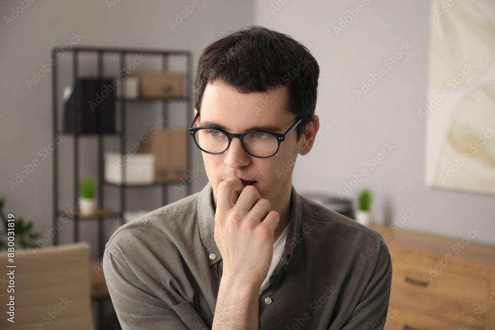 Embarrassed young man in glasses in office Embarrassed young man in glasses in office