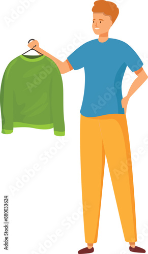 Young man is holding up a green sweater on a hanger, deciding what to wear
