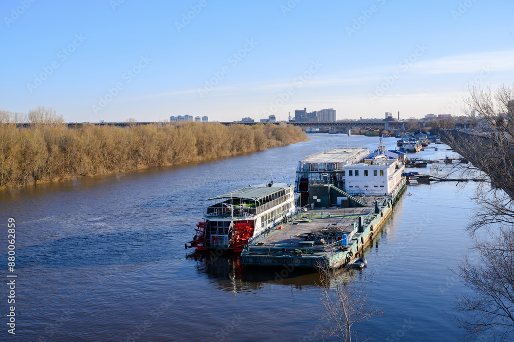 Fototapeta premium A pier with pleasure wheeled boats on the Oka River in Nizhny Novgorod in the spring at sunset