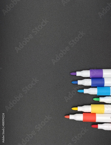 multi-colored markers on a gray background