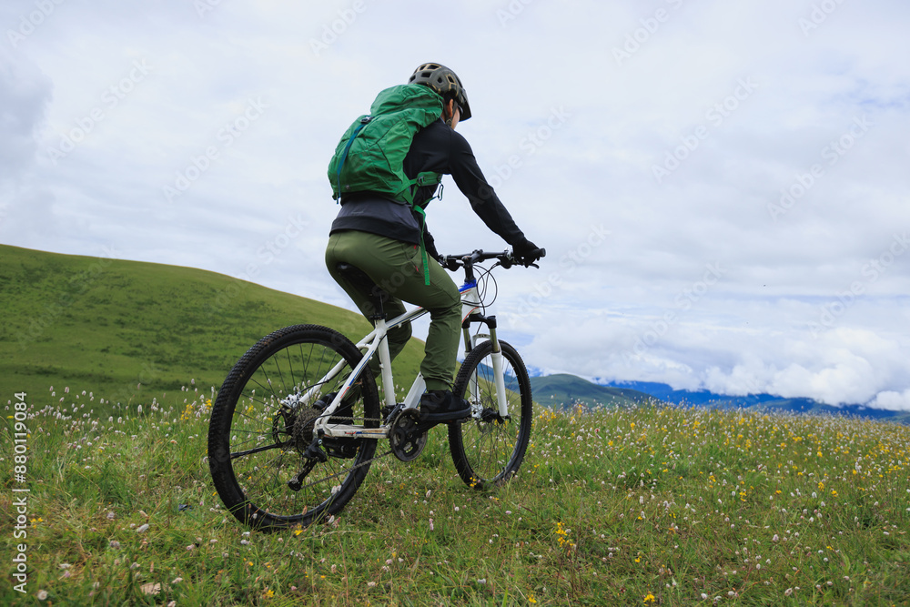 Riding mountain bike on grassland mountain top Riding mountain bike on grassland mountain top