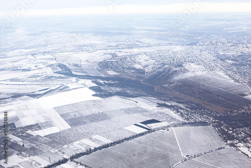 Obraz na płótnie Winter scene with snow covering the ground and frosty trees. Sky is cloudy and the ground is covered in snow. Aerial view of winter countryside w salonie
