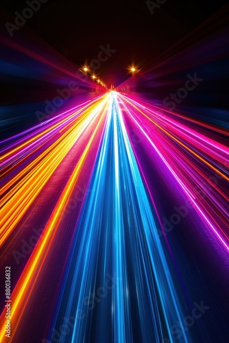 Dynamic long exposure shot of colorful light trails on a dark road at night, showcasing speed, motion, and vibrant colors.