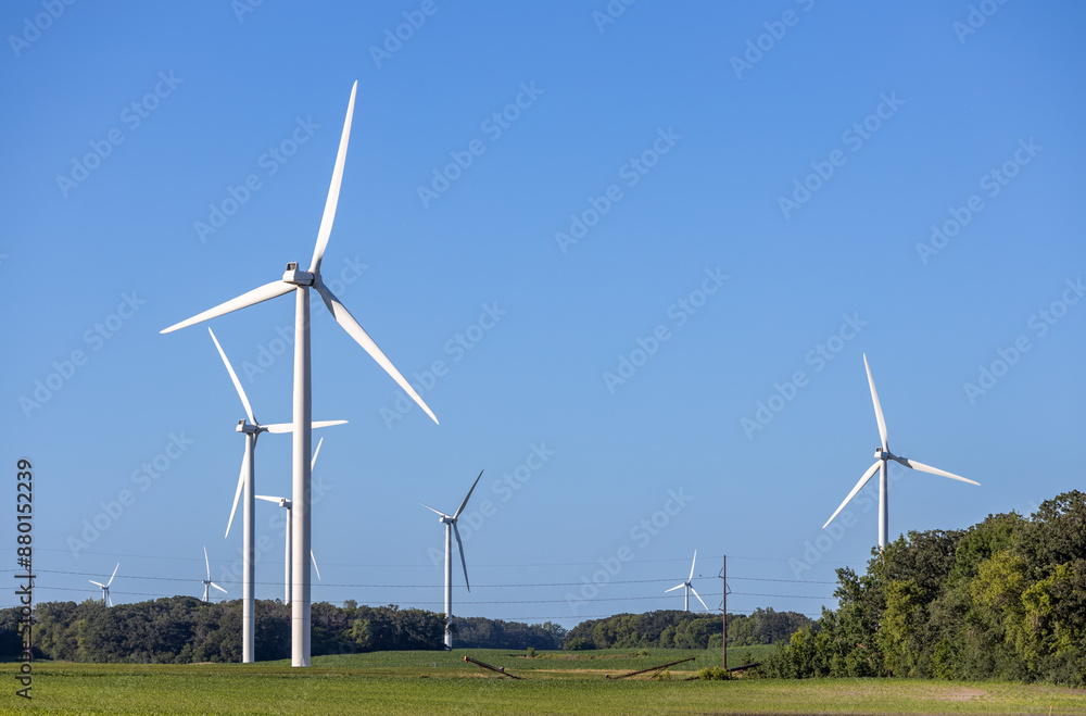 Landscape view of gigantic wind turbines in an agricultural field under clear blue sky, with copy space Landscape view of gigantic wind turbines in an agricultural field under clear blue sky, with copy space