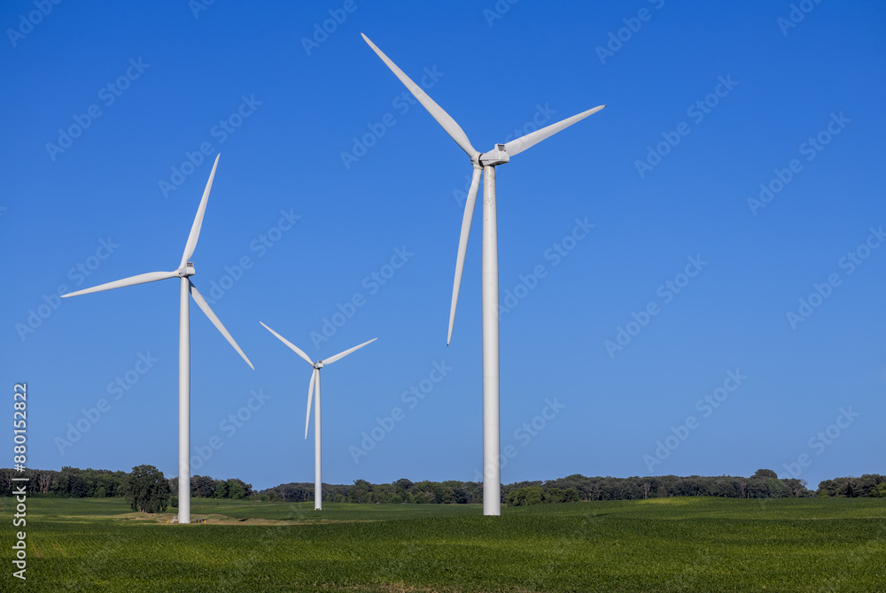 Landscape view of gigantic wind turbines in an agricultural field under clear blue sky, with copy space Landscape view of gigantic wind turbines in an agricultural field under clear blue sky, with copy space