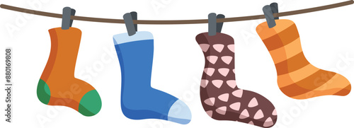 Four socks are hanging on a clothesline, drying after being washed