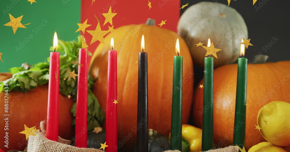 Fototapeta premium Image of golden stars over kwanzaa candles and pumpkins