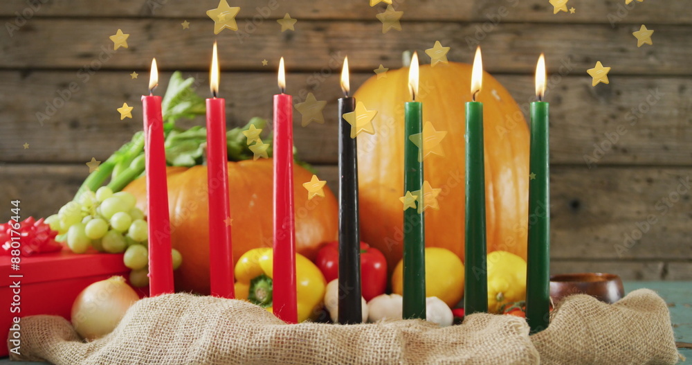 Fototapeta premium Image of golden stars over kwanzaa candles and pumpkins