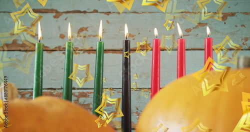 Image of golden stars over kwanzaa candles and pumpkins