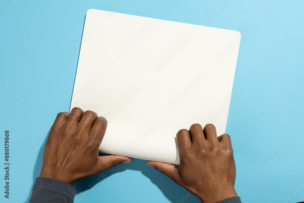 Naklejka premium Biracial man holding a blank whiteboard, with copy space