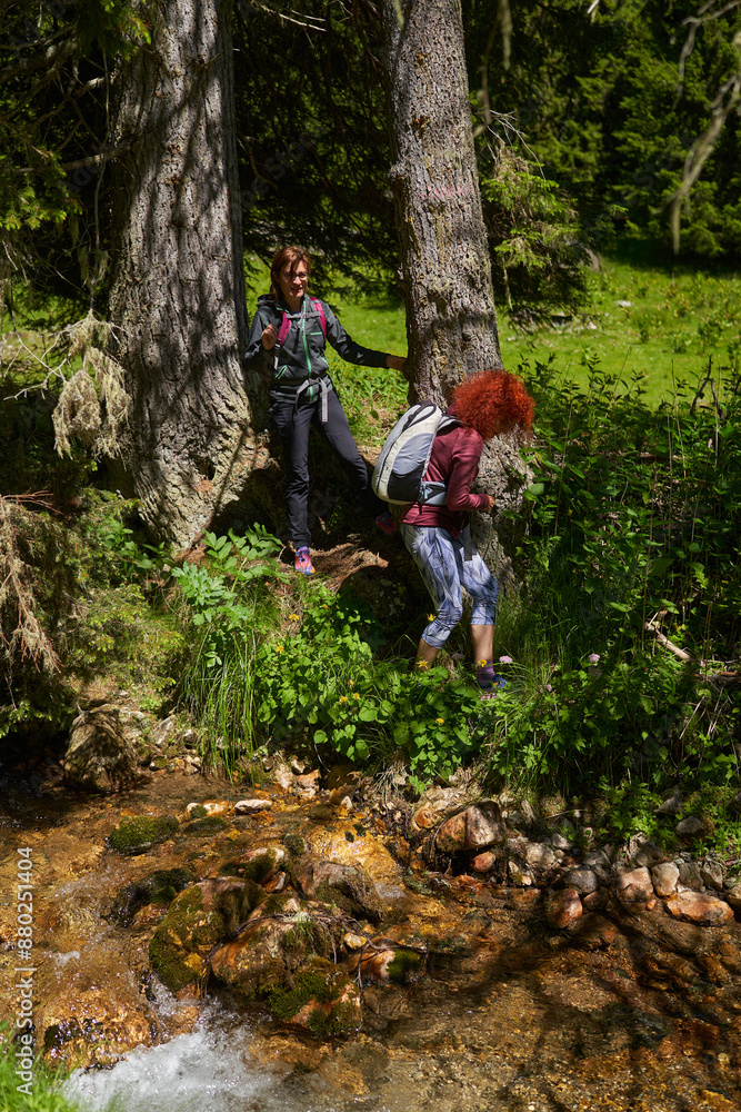 Women with backpacks hiking in the mountains Women with backpacks hiking in the mountains