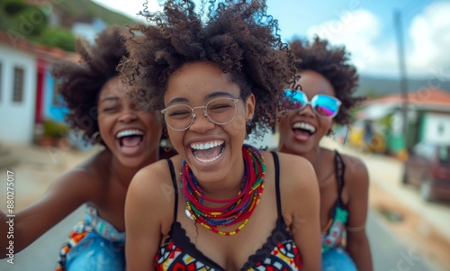 Three joyful young women laughing and enjoying a sunny day outdoors