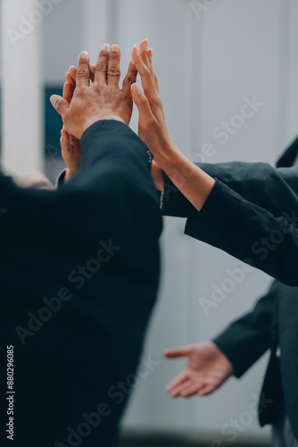 Motivated successful business team giving high five, happy young students employees group join hands with senior teacher mentor, team building unity concept, help support in teamwork, close up view