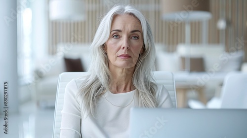 High-angle shot of a mid-aged woman sitting at her desk in the office, looking overwhelmed and fatigued, with a soft-focus background of office furniture. Free Download High-angle shot of a mid-aged woman sitting at her desk in the office, looking overwhelmed and fatigued, with a soft-focus background of office furniture. - GFXLoad
