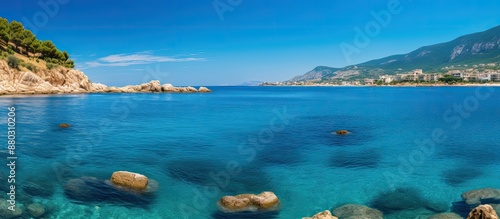 Sunny day along the rocky southern Italian coast with a vibrant blue Mediterranean Sea providing a serene backdrop for a copy space image.