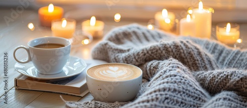 Scandinavian lifestyle illustrated in a hygge-themed home setting with a cup of coffee, candles, blanket, and a book, perfect for relaxation, featuring a copy space image. photo